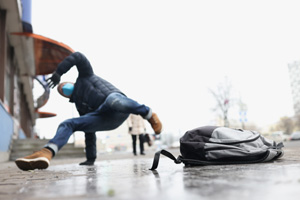 Male person get injury after falling on slippery ground in winter