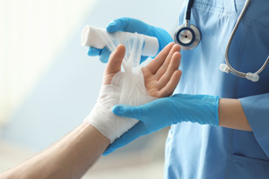 Doctor applying bandage onto patient's hand