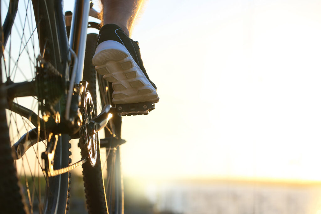 Male cyclist riding bicycle outdoors, closeup