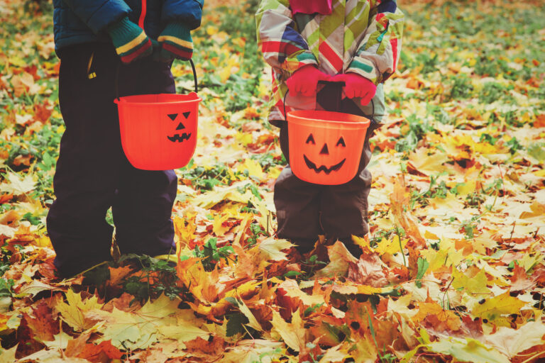 little boy and girl trick or treating in fall nature, halloween concept